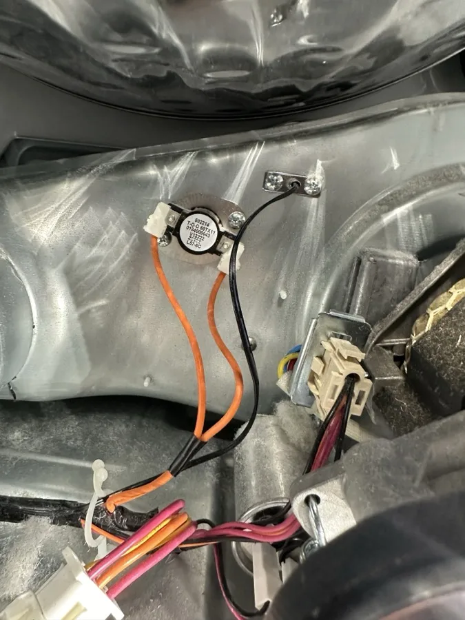 Dryer thermostat replacement during dryer heating system repair