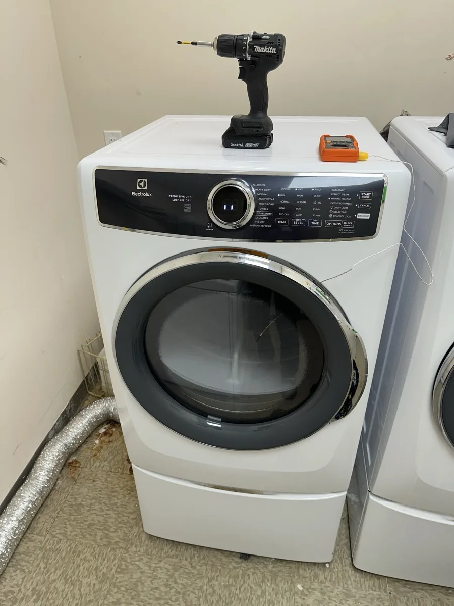 Electrolux front load dryer repair service with technician tools on top